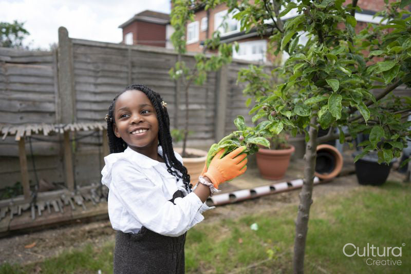 Smiling girl touching tree branch