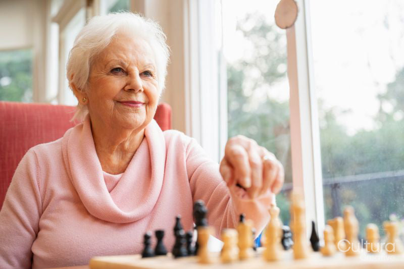 Senior woman playing chess in nursing home
