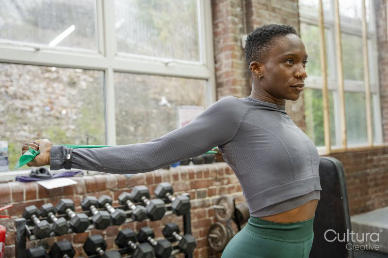 Athletic woman exercising with resistance band at gym
