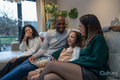 Smiling family relaxing on sofa at home