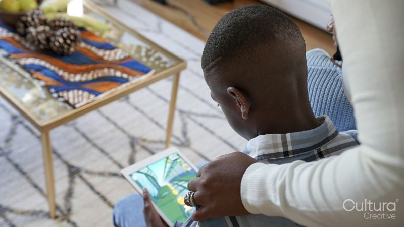 Mother and son playing game on tablet at home