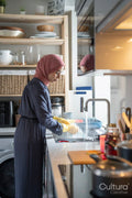 Mid adult woman in hijab washing dishes at home