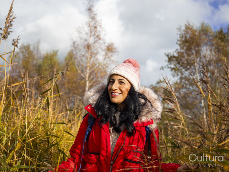 Smiling female hiker walking through tall grass