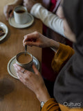 Woman stirring tea with milk