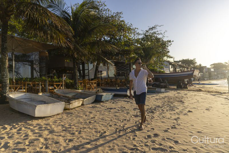 Man walking along beach and talking on phone