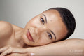 Studio portrait of shirtless woman leaning on arm