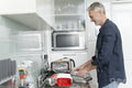 Smiling mature man preparing meal in kitchen