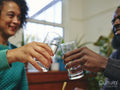 Couple raising toast with glasses of water