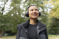 Portrait of smiling woman in sports clothing and headphones in park