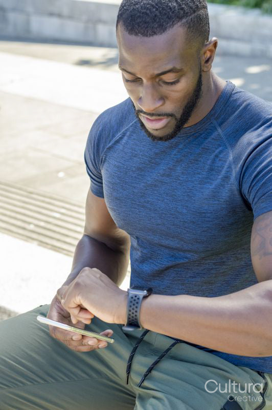 Mid adult man checking time on smart watch