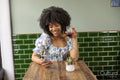 Smiling woman with glass of red wine and smart phone at cafe table