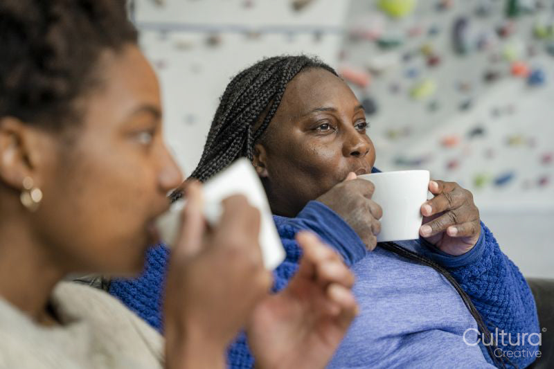 Mother and daughter drinking coffee after training on climbing wall