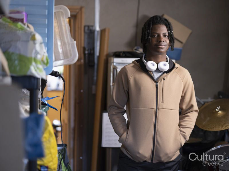 Portrait of teenage boy standing next to drums