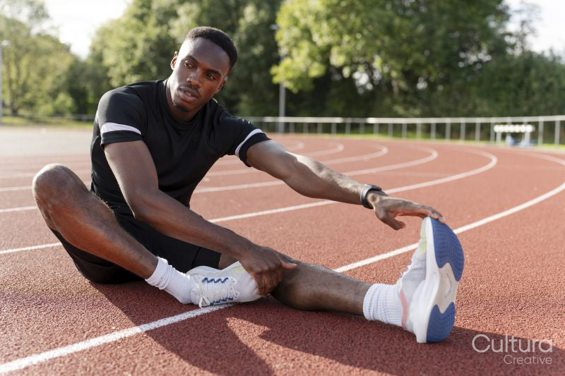 Athlete stretching legs before training at sports track