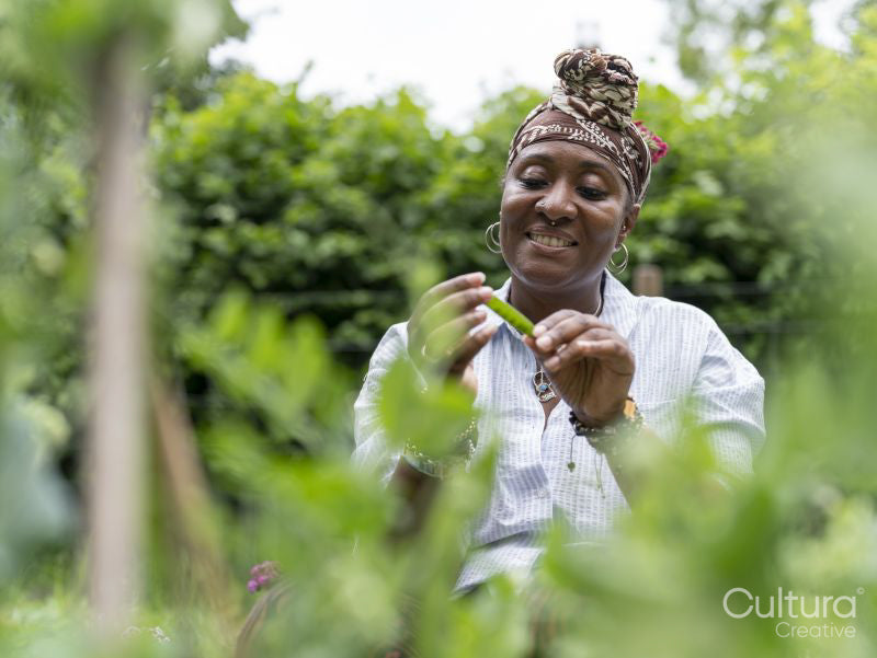 Woman holding green beans collected from garden