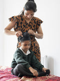 Mother wrapping traditional turban on son's head