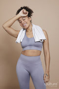 Studio portrait of smiling athletic woman with towel around neck