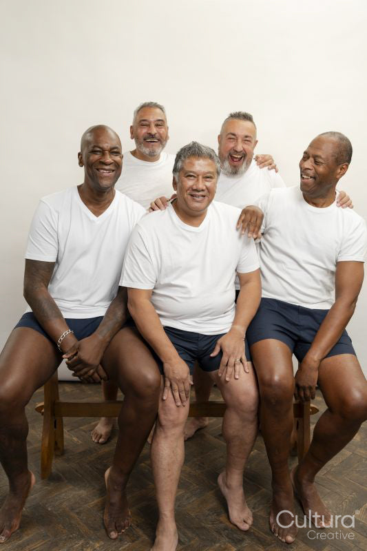 Group portrait of smiling senior men in white t-shirts against gray background