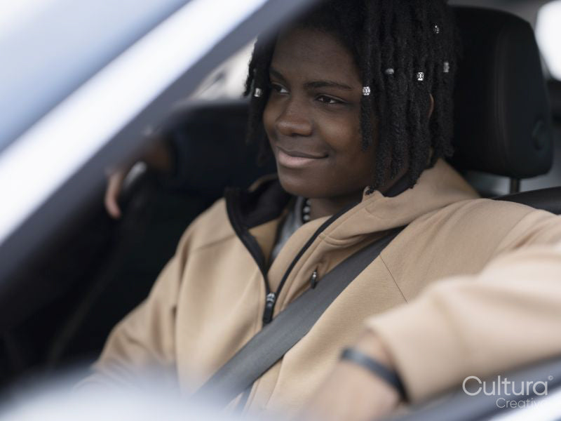 Smiling teenage boy sitting in car