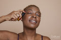 Studio portrait of woman applying serum on face