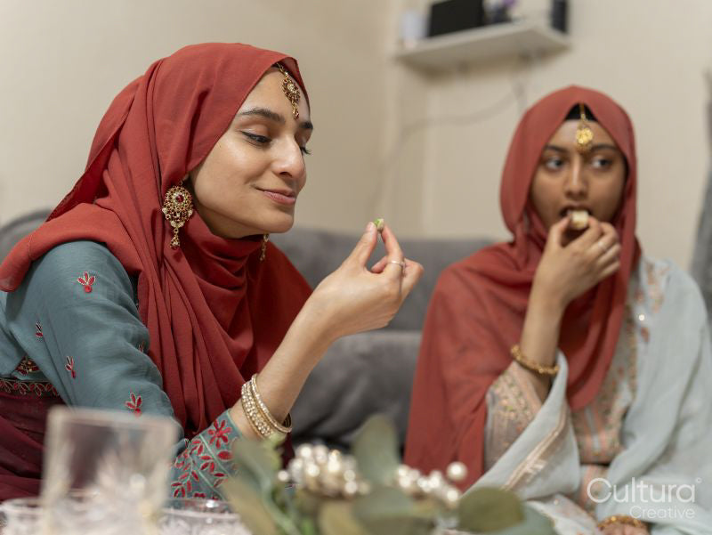 Women eating snacks during Ramadan celebration at home