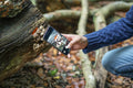 Man photographing mushroom with smart phone in forest