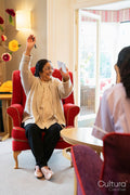 People playing bingo at nursing home, cheerful senior woman raising arm