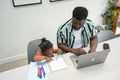 Father using laptop and daughter drawing in notepad