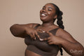 Studio portrait of smiling young woman with gesturing heart sign