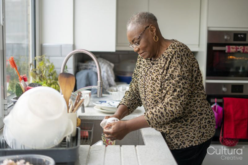 Woman washing dishes in kitchen