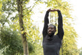 Portrait of smiling athletic man stretching in park