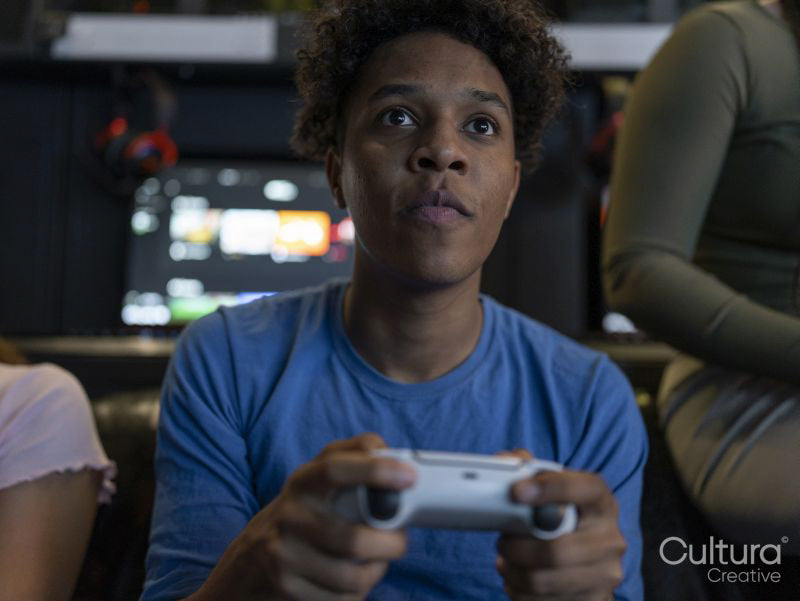 Serious man playing video games with friends in gaming club