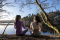 Young women meditating at lake