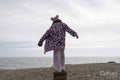 Girl standing on groyne and looking at sea view