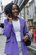 Smiling woman talking by smart phone in city