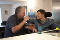 Father and disabled son laughing at home