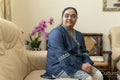 Portrait of young woman with down syndrome sitting on sofa at home