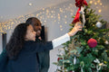 Father and daughter looking at Christmas tree at home