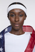 Studio portrait of athletic woman wrapped in American flag
