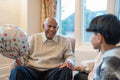 Smiling senior man looking at grandson during visit in nursing home