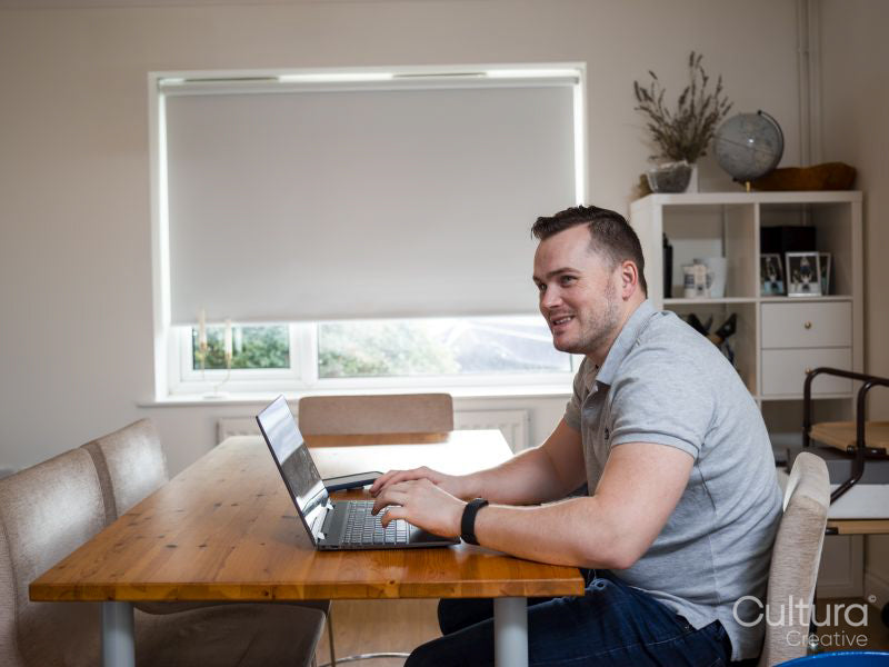 Smiling man using laptop at home