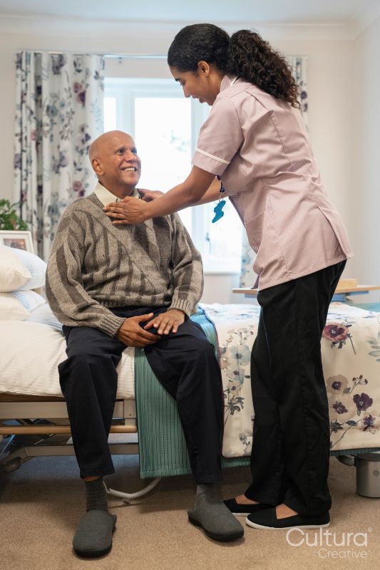 Nurse helping senior man to get dressed at nursing home