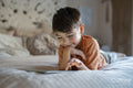 Boy using digital tablet in bedroom