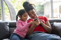 Two girls sitting on sofa looking at smartphone