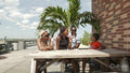 Smiling family eating ice cream at wooden table on pier