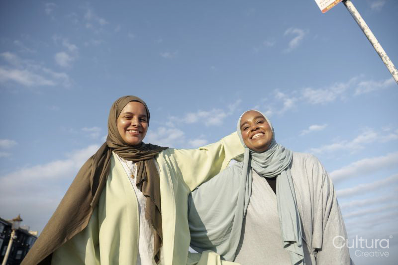 Portrait of smiling Muslim women looking at camera on sunny day