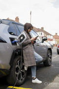 Woman wearing hijab charging electric car