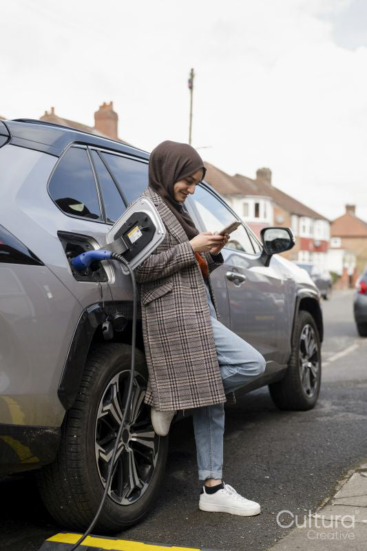 Woman wearing hijab charging electric car