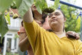 Mother with down syndrome daughter looking at flowers in garden