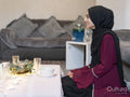 Smiling woman sitting at table during Ramadan celebration at home